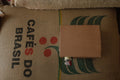 A box of coffee concentrate sat on top of a bag of specialty Brazilian coffee 